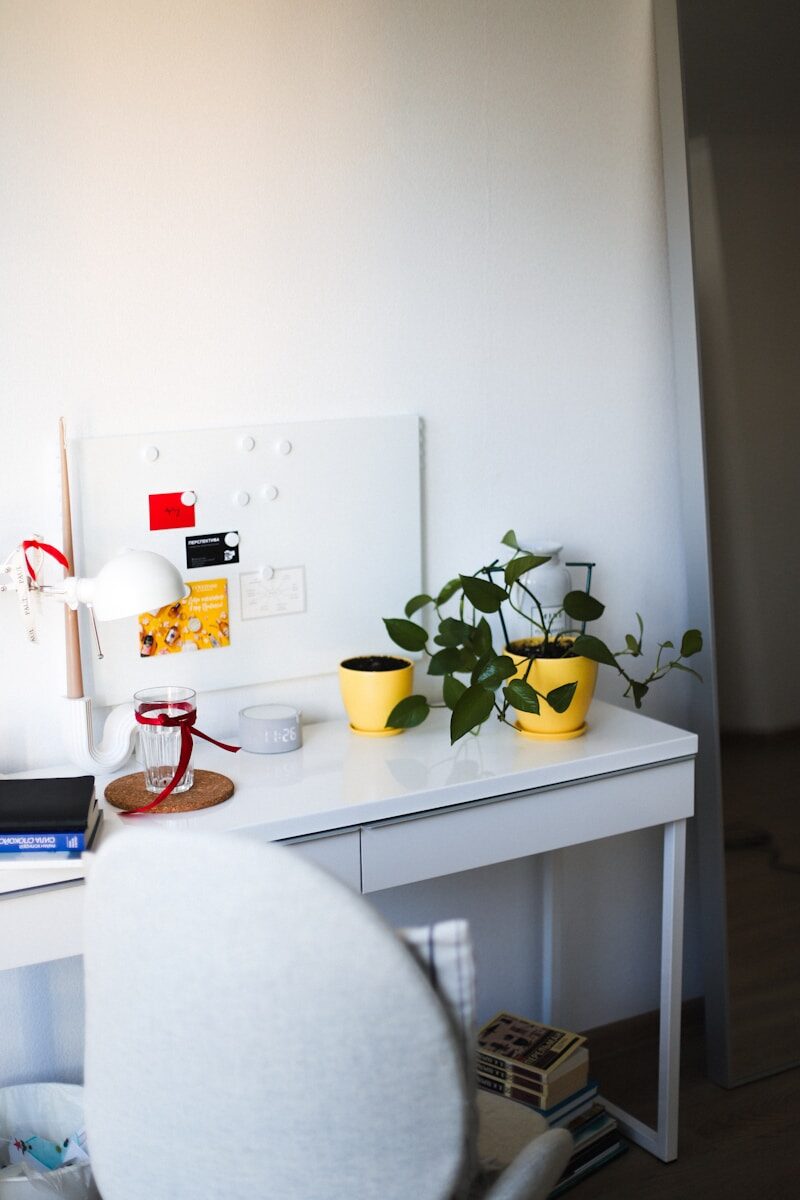 Desk with plants, lamp, and whiteboard