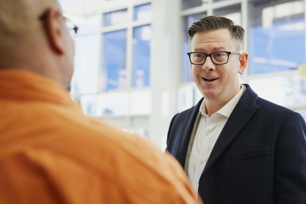 Two business professionals engaged in a conversation in an office setting.