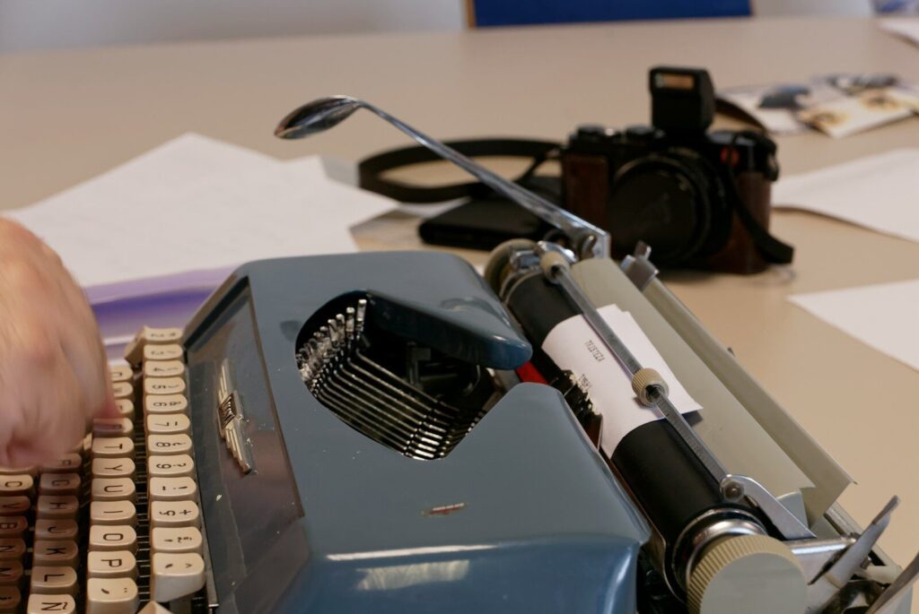 a person typing on an old fashioned typewriter