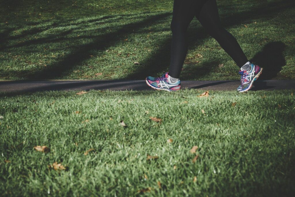 25 Refreshing Things to Do Outside by Yourself 2 shallow focus photography of person walking on road between grass