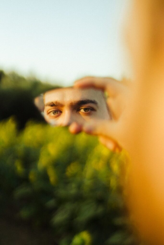 23 Things To Tell Yourself Every Morning 7 Man's eyes reflected in a handheld mirror outdoors
