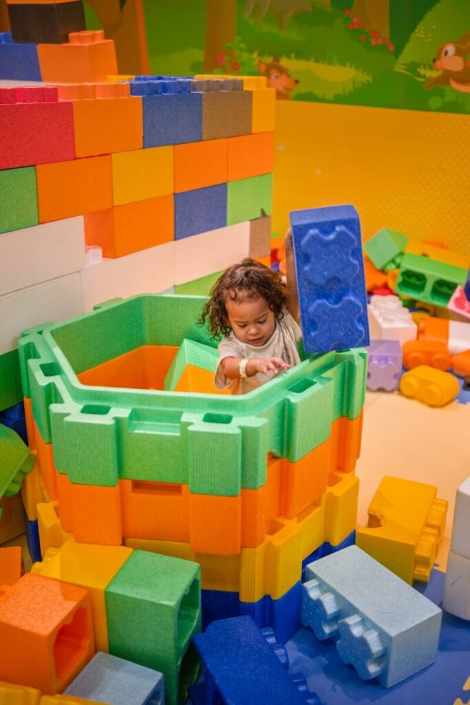 13 Cognitive Development Activities to Boost Brain Growth in Kids 5 A child plays with large colorful building blocks.