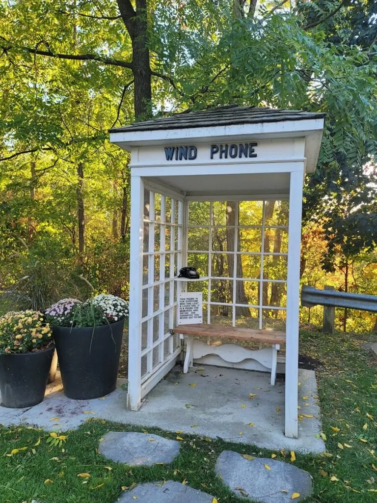 60 Meaningful Things to Do With Your Parents for Every Season and Situation 8 A white booth labeled "wind phone" with a bench inside.