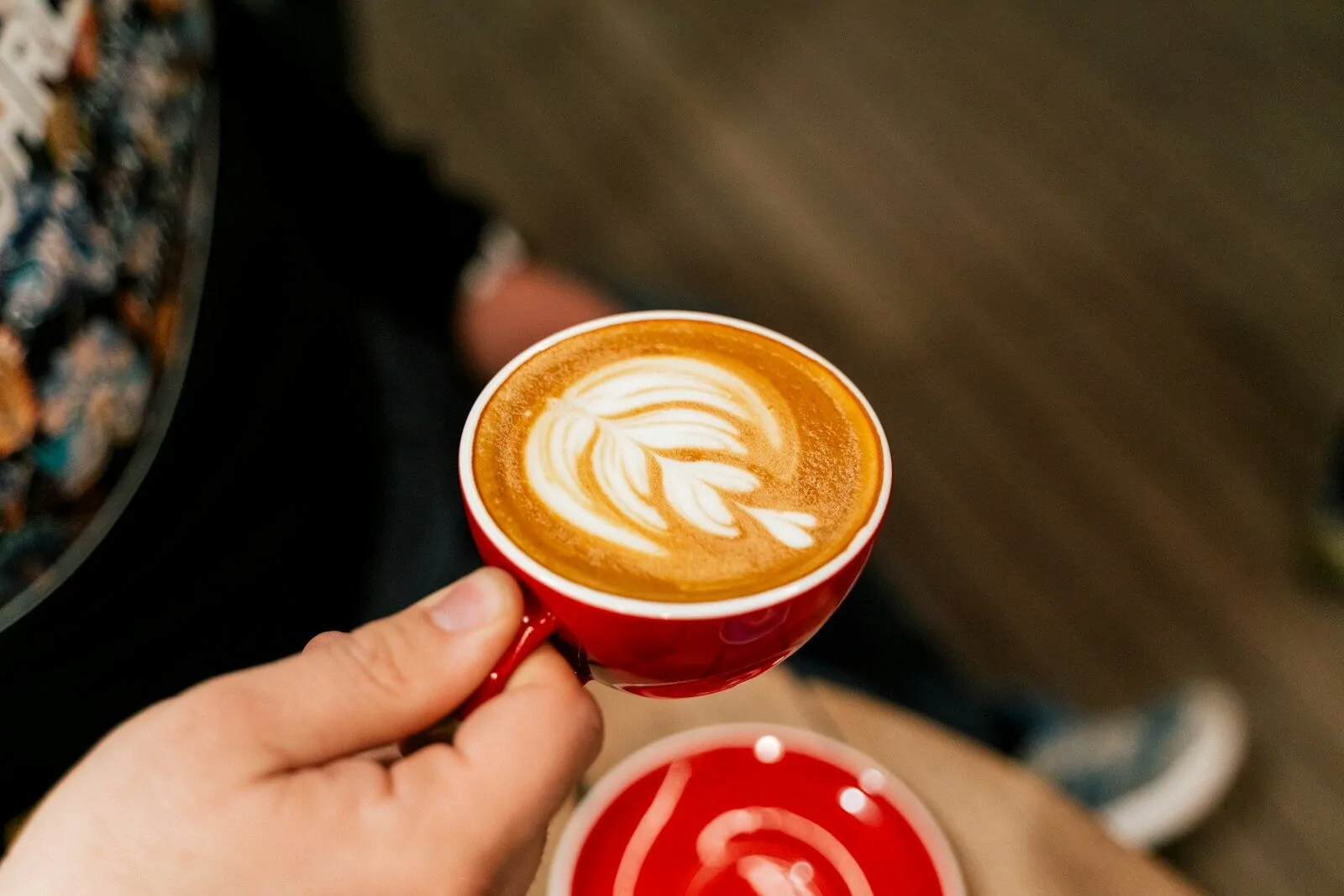 a person holding a cup of coffee in their hand