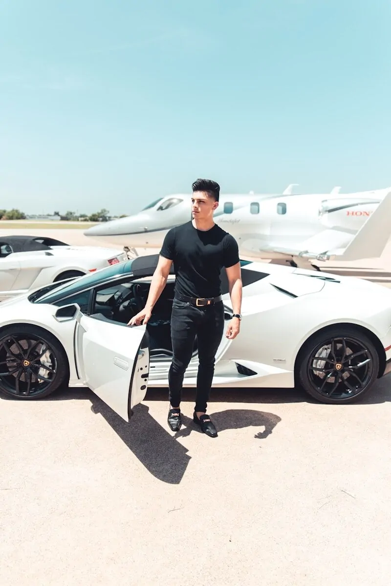 Why Entrepreneurs Aim for Wealth, Not Just Being Rich 3 man in black by a white sports car