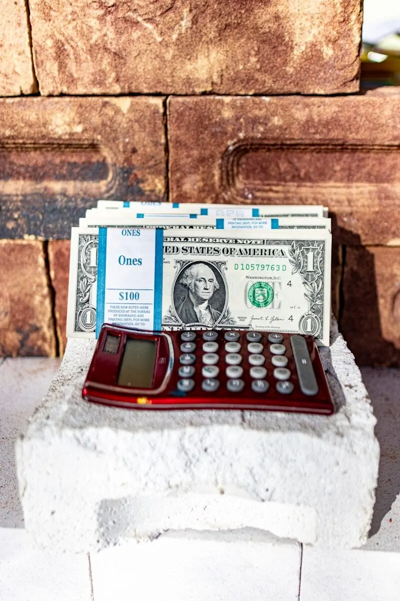 Why Entrepreneurs Aim for Wealth, Not Just Being Rich 4 a red calculator sitting on top of a pile of money