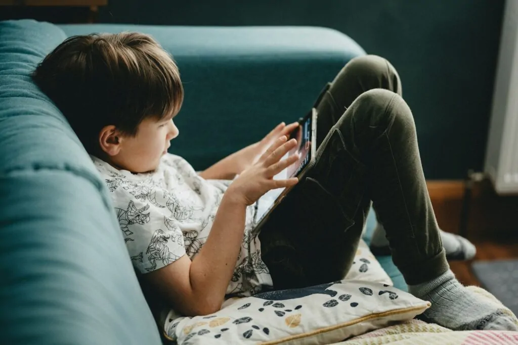 10 Low Screen Time Activities Kids Actually Love 1 boy in white shirt and black pants sitting on couch