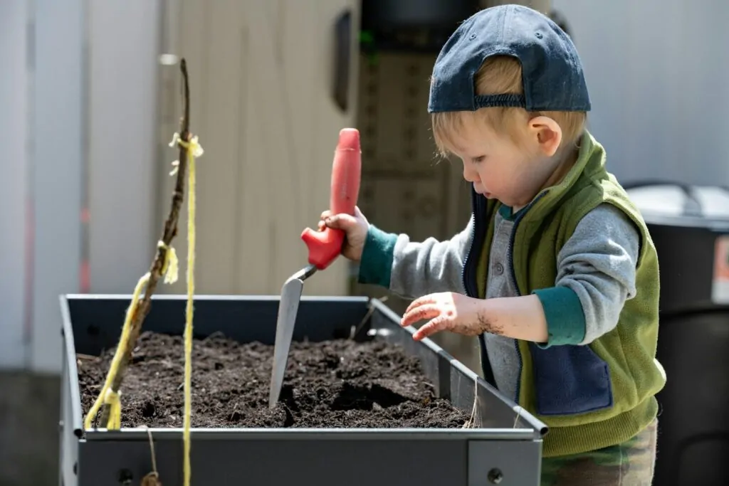 10 Low Screen Time Activities Kids Actually Love 3 a young boy using a red tool to stir a substance in a container