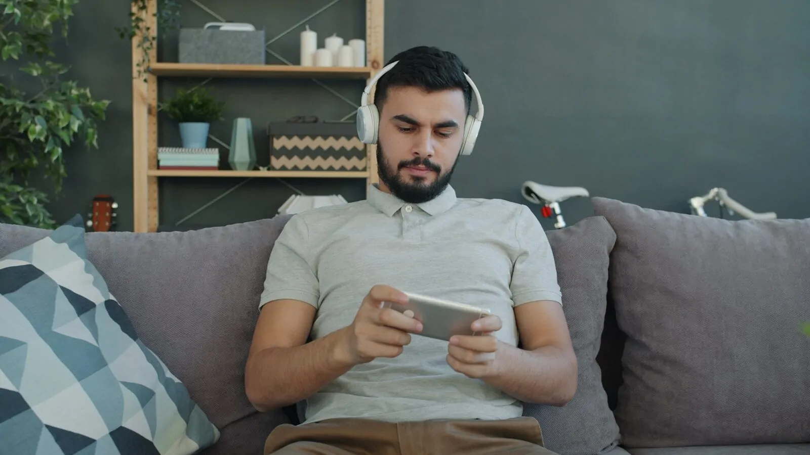 21 Screen Time Hacks That Changed My Life in 30 Days 1 Man wearing headphones plays game on phone