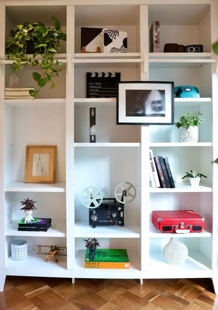 Contemporary bookshelf featuring vintage decor items, books, and greenery for a stylish home interior.