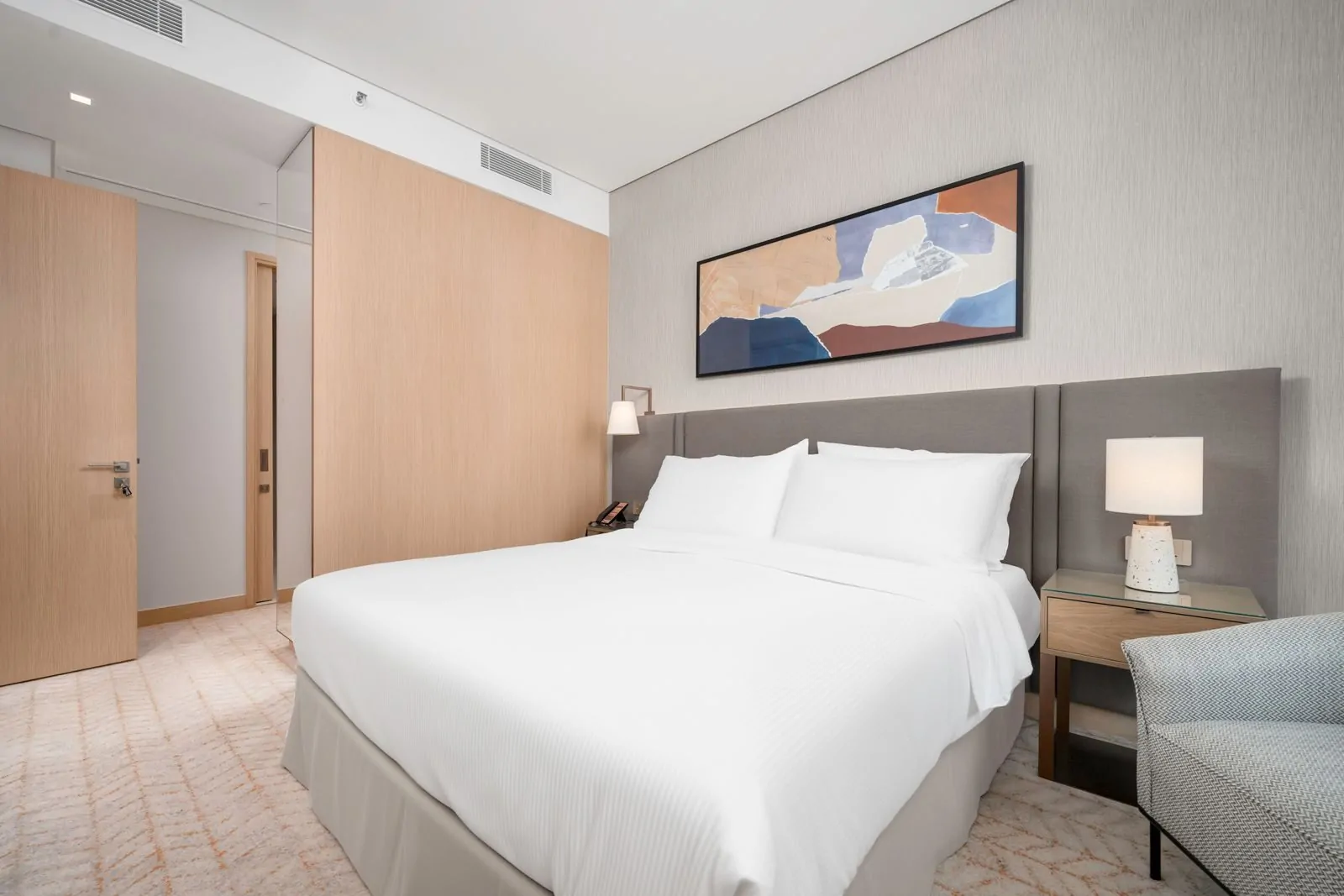 35+ Room Decor Ideas for Small Spaces That Feel Bigger 33 Spacious modern hotel room interior with a comfortable bed and elegant decor.