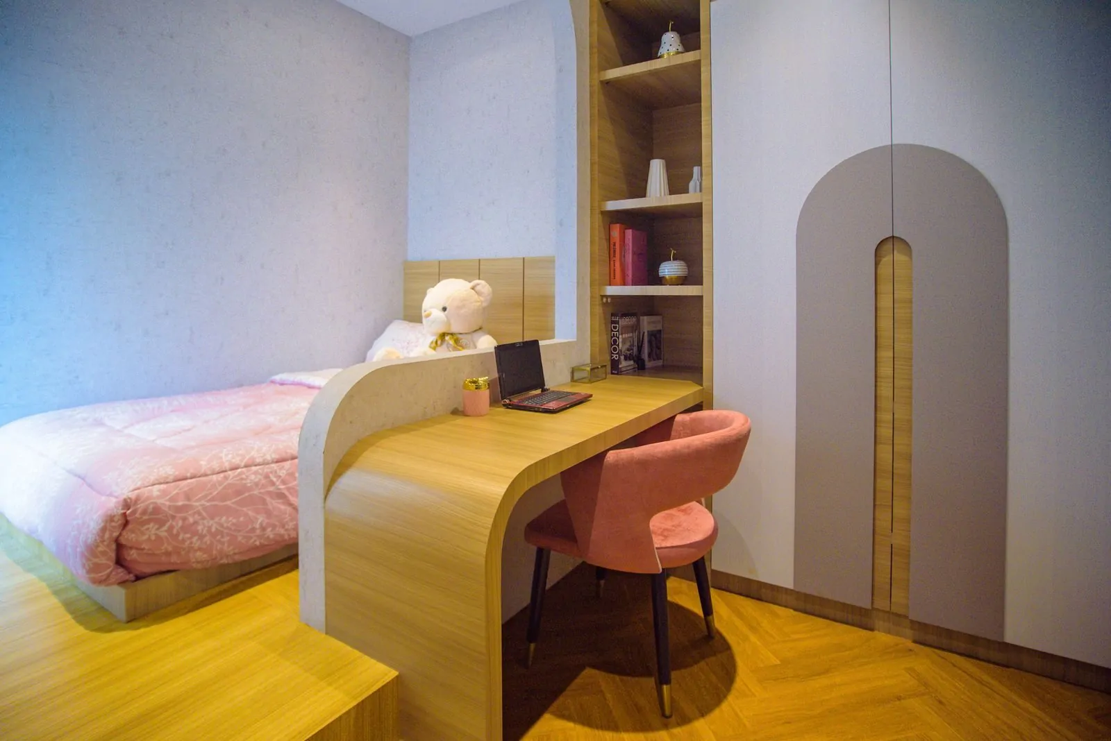 35+ Room Decor Ideas for Small Spaces That Feel Bigger 36 A modern cozy bedroom featuring a study desk with a laptop, pink bedding, and decorative elements.