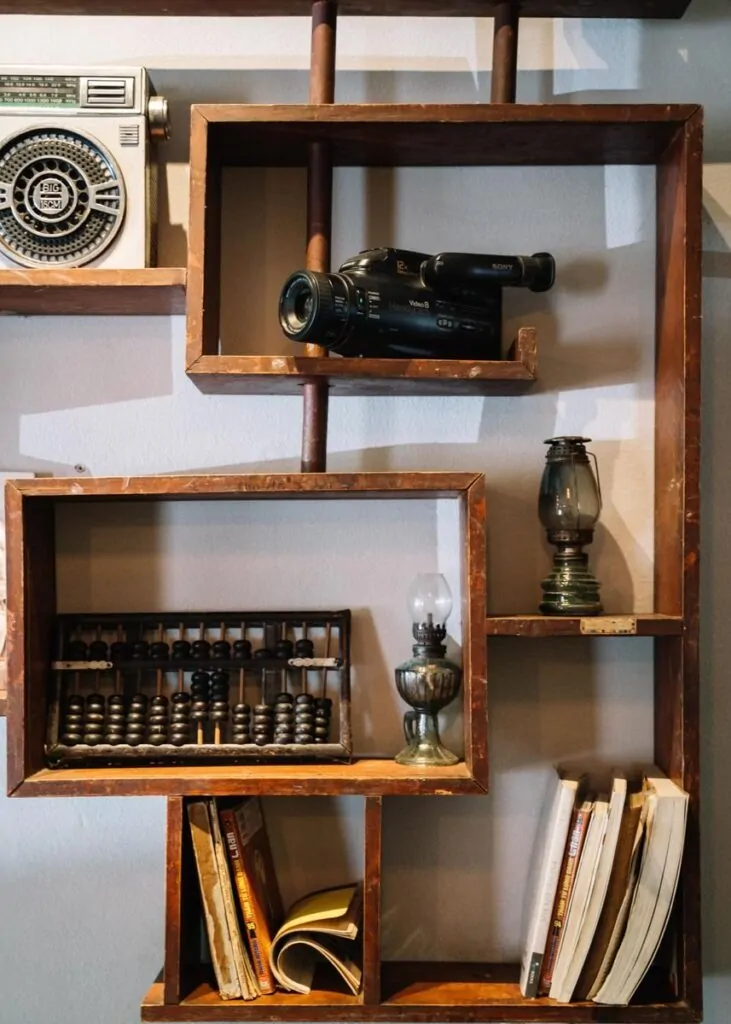 A stylish vintage wooden shelf with retro camera, books, and antique items for unique decor.