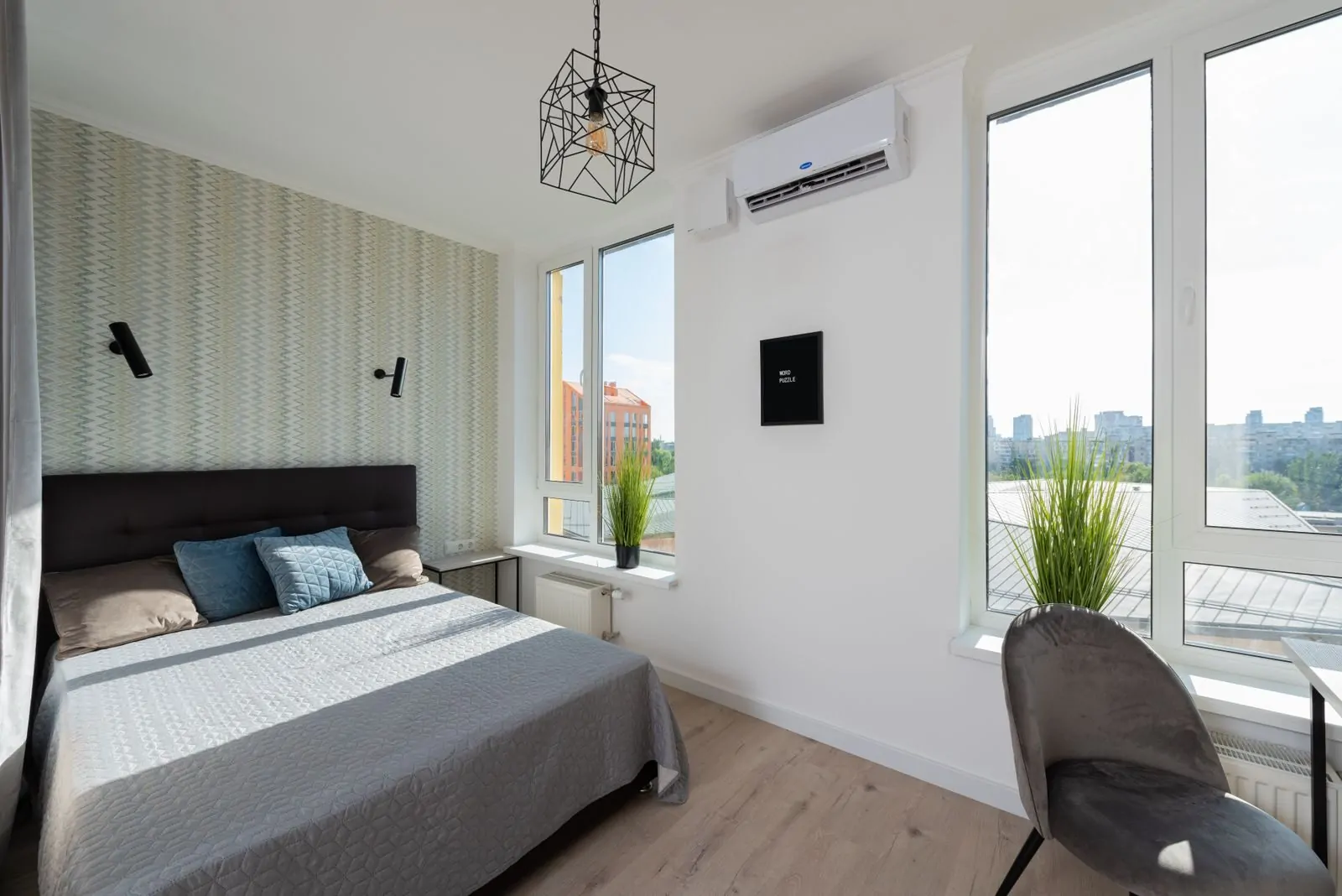 35+ Room Decor Ideas for Small Spaces That Feel Bigger 19 Interior of modern light bedroom with pillows and blanket on bed near table and windows with potted green plants on windowsill next to chair