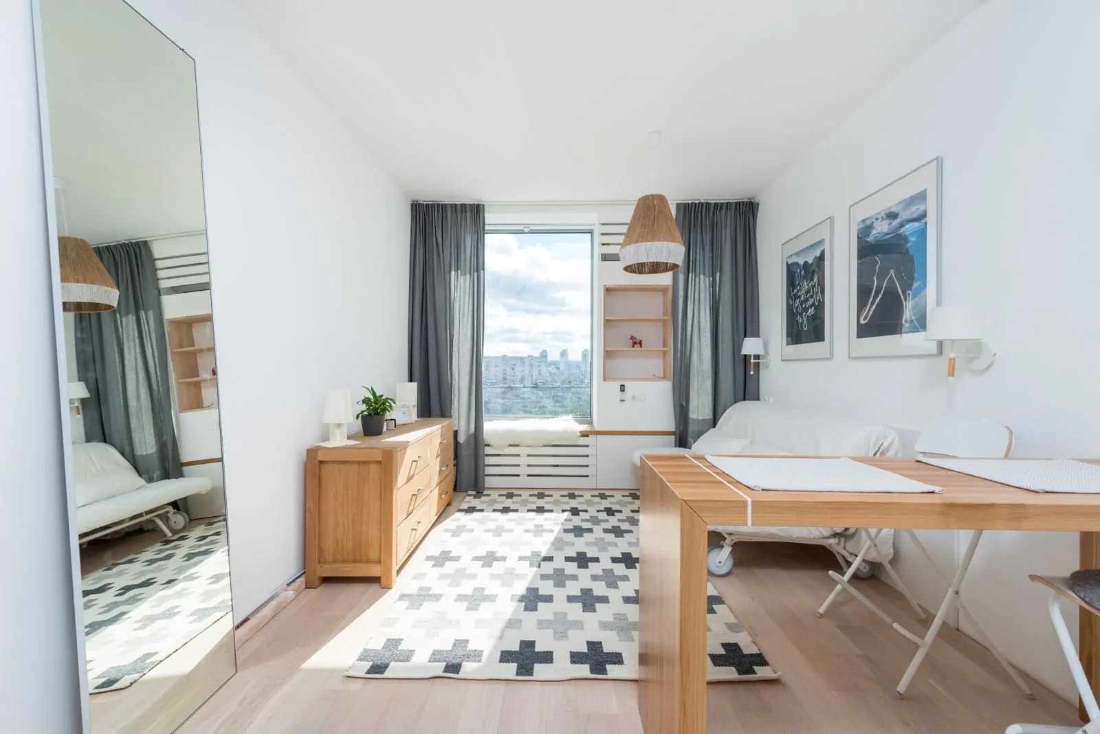 35+ Room Decor Ideas for Small Spaces That Feel Bigger 13 Wooden table and drawer placed in room with big window and wall decorated with pictures in light room with mirror