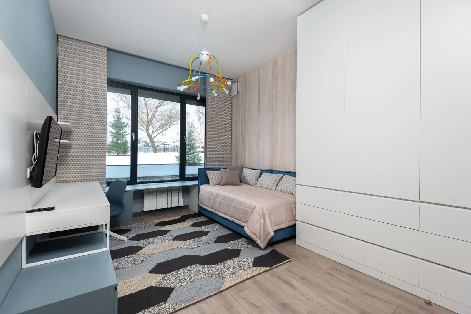 35+ Room Decor Ideas for Small Spaces That Feel Bigger 22 Interior of cozy bedroom with sofa bed and big wardrobe placed in front of table and TV hanging on wall