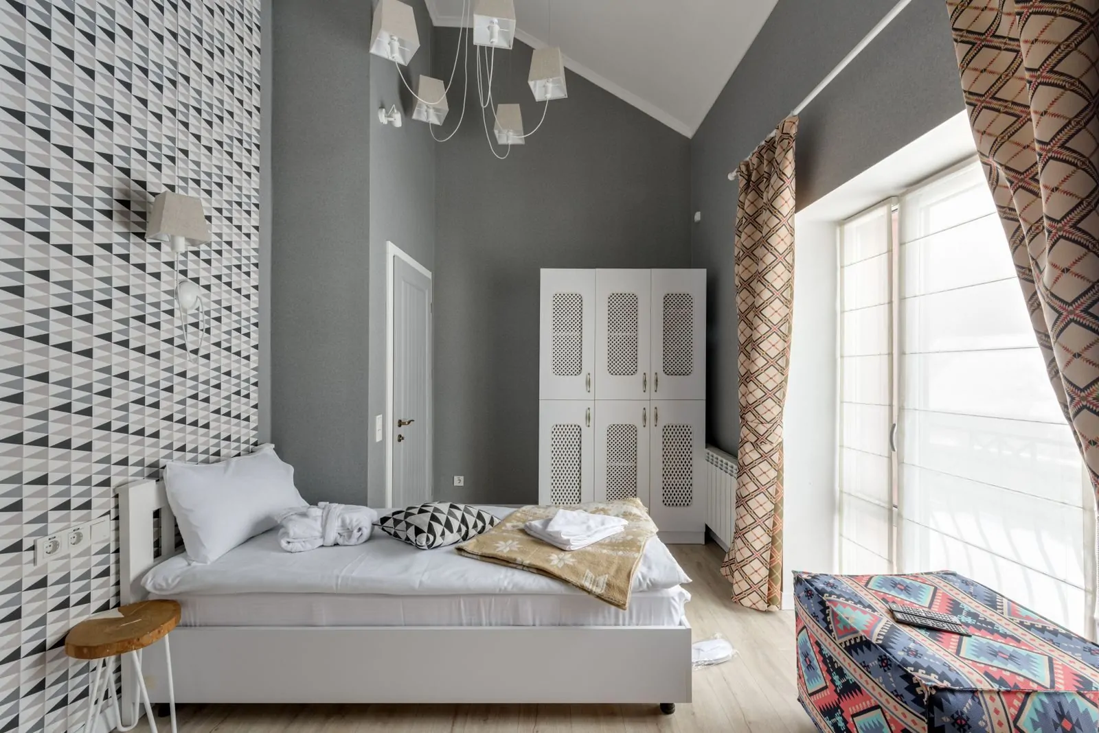 35+ Room Decor Ideas for Small Spaces That Feel Bigger 23 Stylish contemporary bedroom featuring geometric wallpaper, natural light, and chic furnishings.