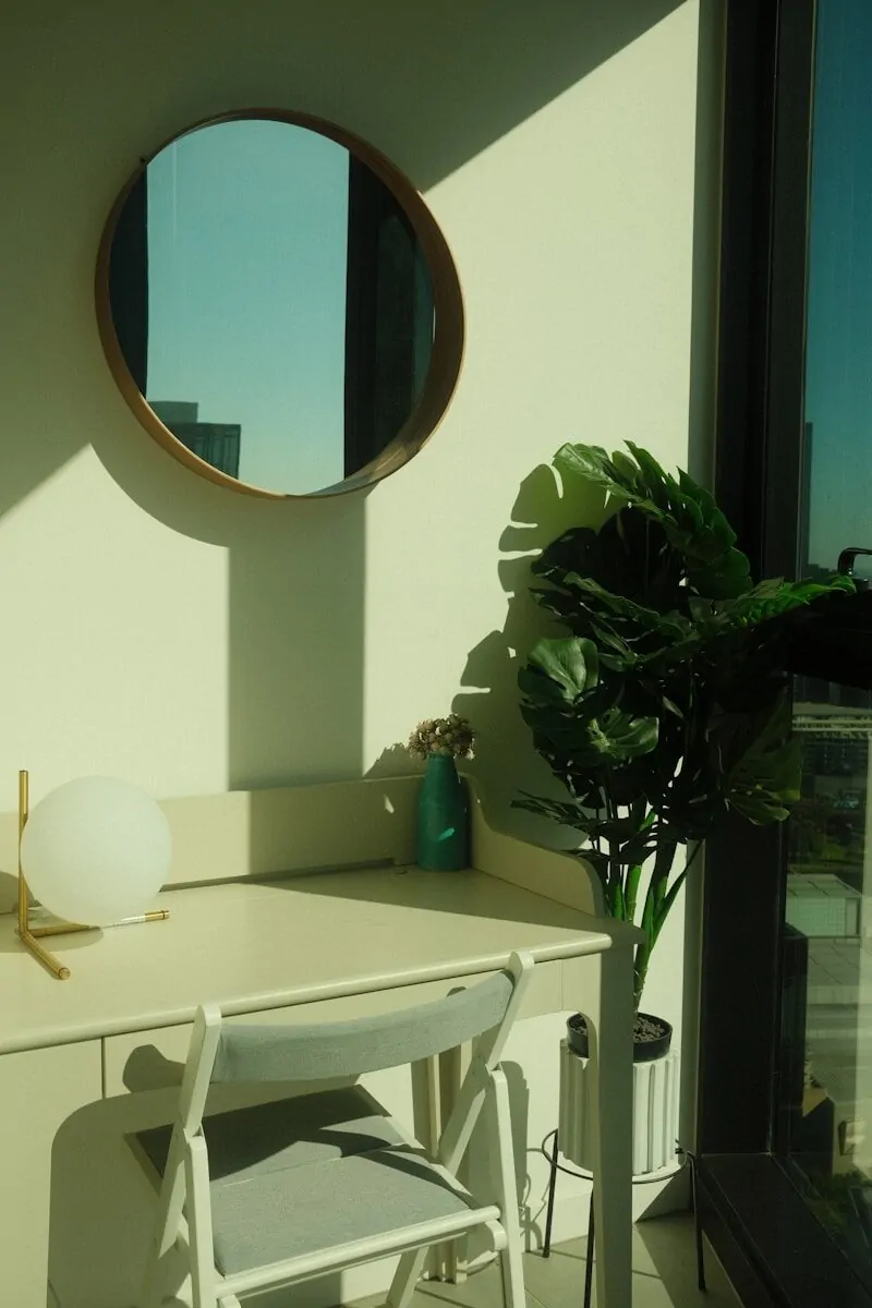 35+ Small Office Ideas for Working From Home 10 a white desk with a mirror and a potted plant