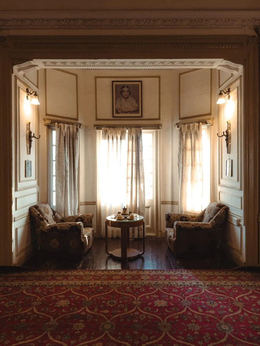 50 Luxury Living Room Ideas for Every Home Style 41 Elegant sitting area with armchairs, table, and sunlit windows.