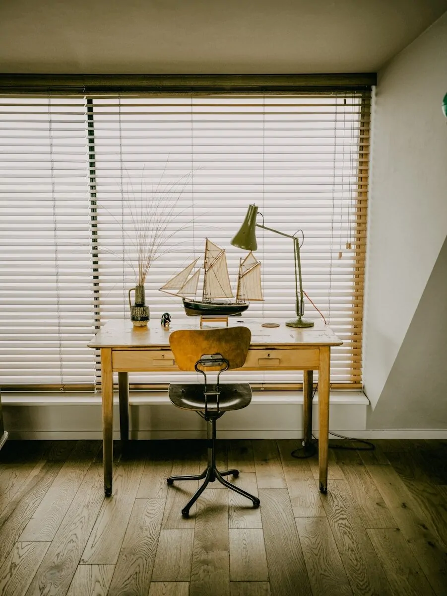 35+ Small Office Ideas for Working From Home 37 Desk with model ship and lamp by window