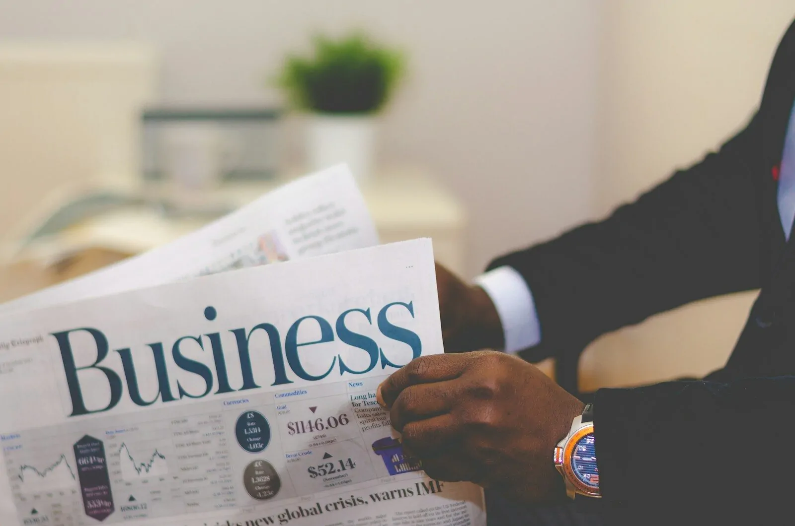 Business Professor Says These 5 Skills to Learn Before Starting a Business 1 person wearing suit reading business newspaper