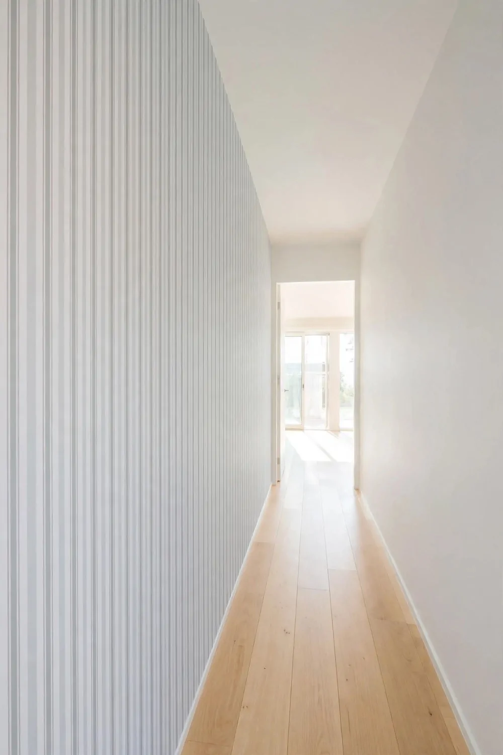 18 Hallway Decor Ideas That Make a Narrow Space Shine 13 Striped wallpaper on a narrow hallway wall, bright light, airy