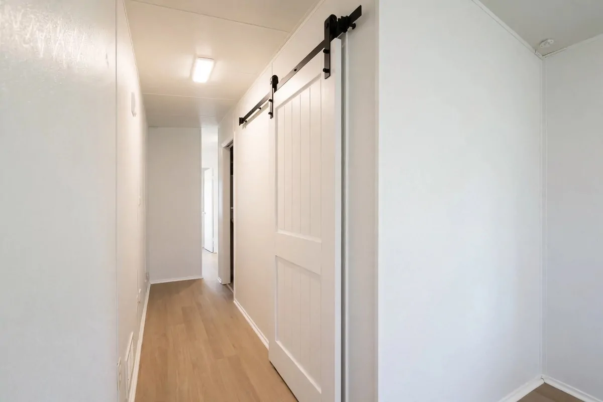 19 Singlewide Mobile Home Ideas That Look Like a Full Remodel 11 Bedroom closet with sliding barn door in a singlewide hallway
