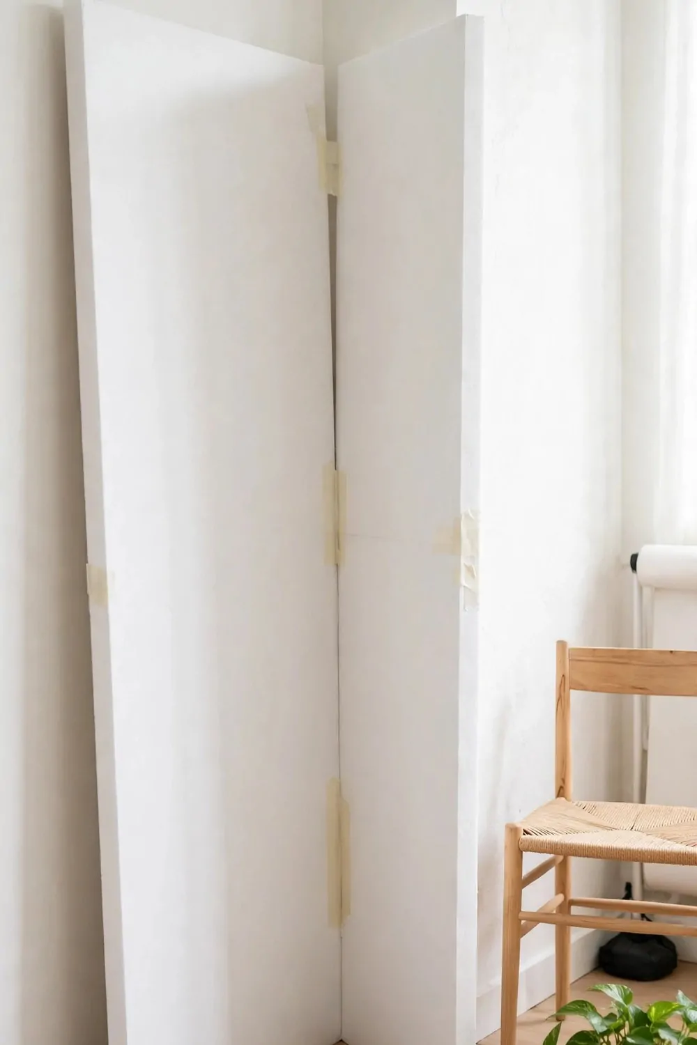 19 Small Photo Studio Setups That Still Look Professional 6 Two large white foam boards taped together in a V shape standing in a small photo studio corner