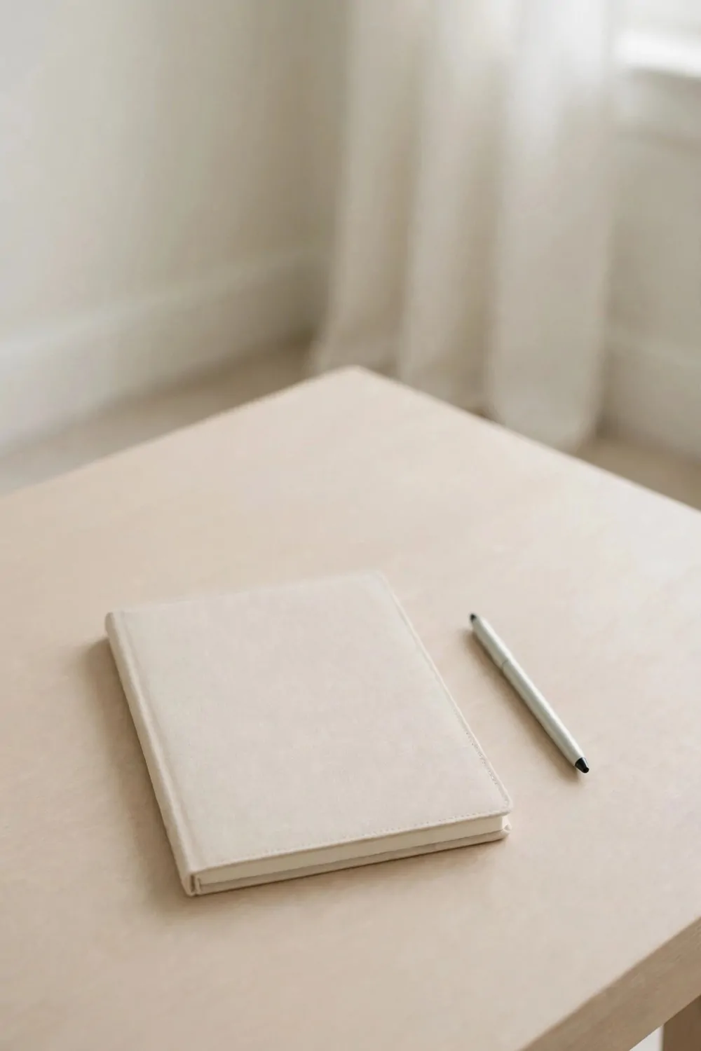 19 Work Space in Bedroom Ideas That Actually Feel Calm 4 A clear tidy desk top in a pale bedroom office, one notebook and one pen, nothing else, soft light