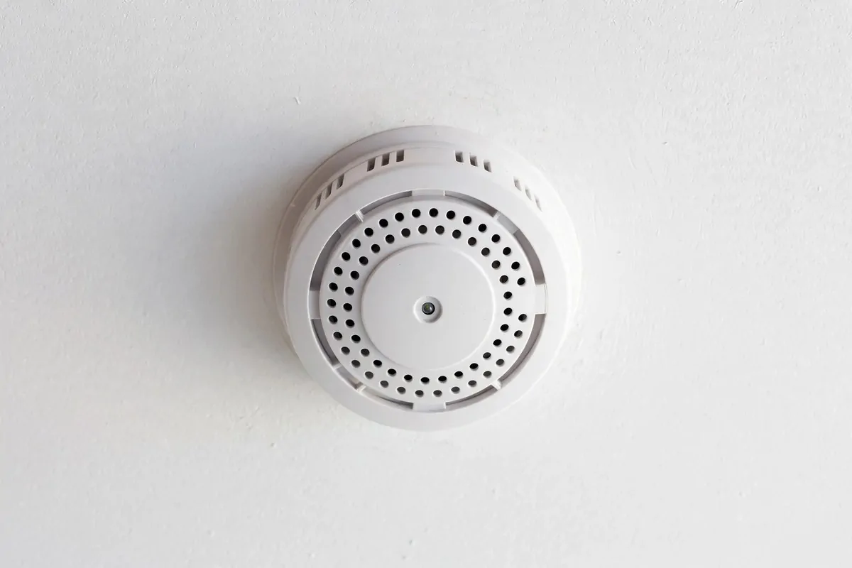 21 New Home Ideas to Try Before You Even Unpack 6 white smoke detector mounted on a clean ceiling in a new home