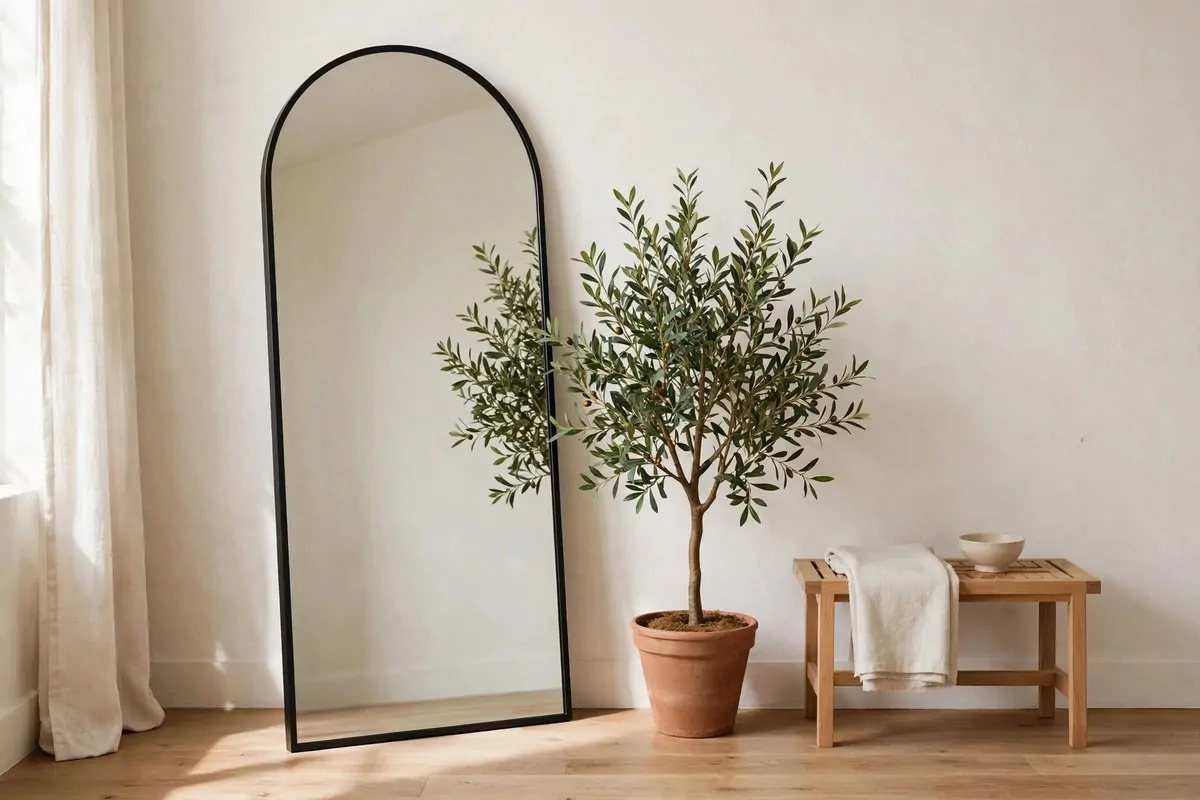 21 Thrifted Home Decor Finds That Look High-End 21 Arched floor mirror with slim black frame in a bedroom