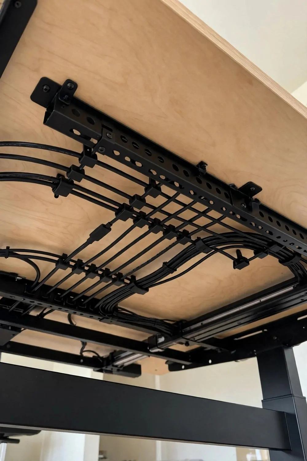 24 Home Office Interior Design Tricks Designers Swear By 17 A tidy desk underside with a mounted cable tray and clipped cables, no loose wires in sight