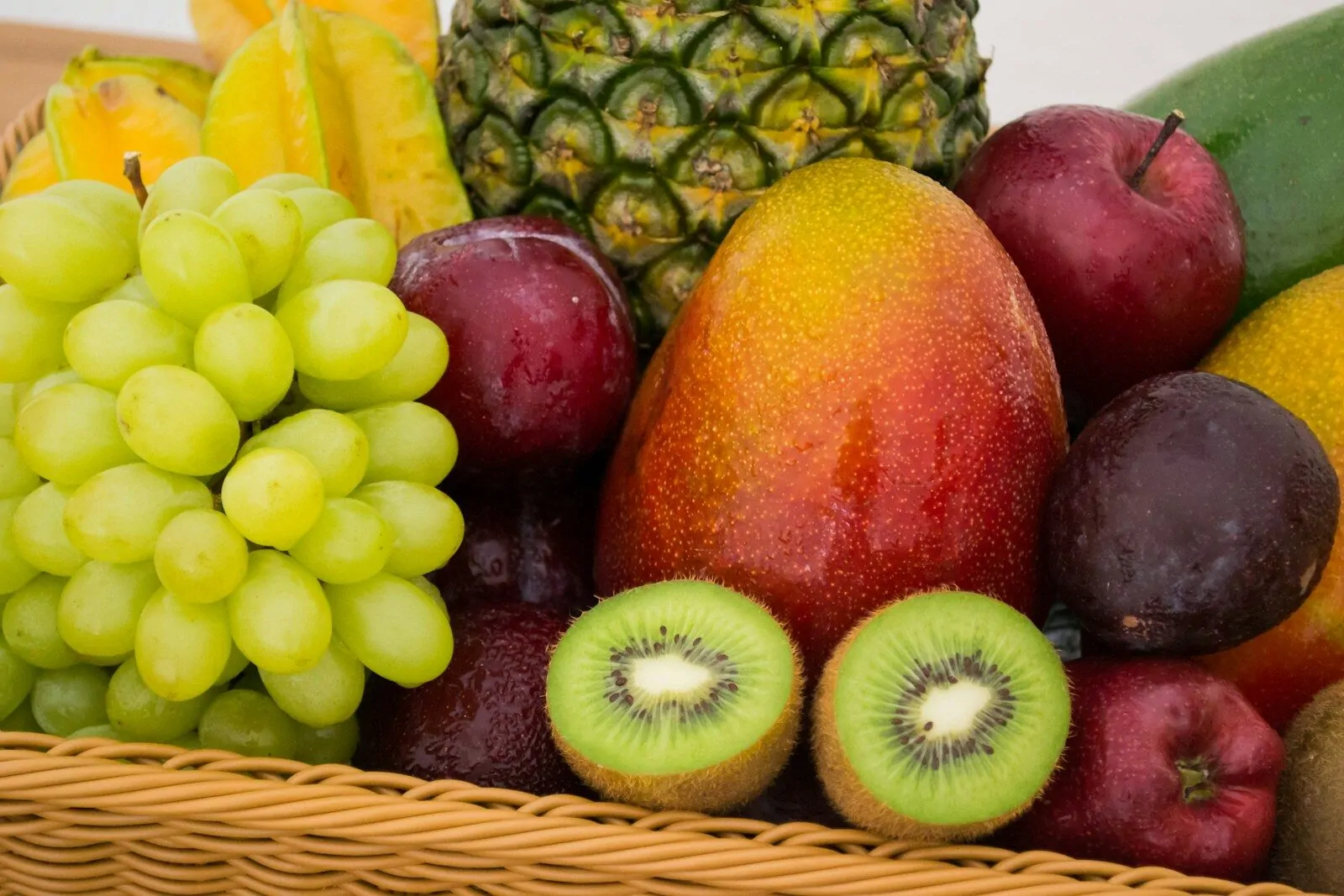 Can You Name These Fruits? Test Your Fruit Knowledge With This Fun Quiz! 1 Basket filled with assorted fresh fruits including grapes, mango, pineapple and kiwi