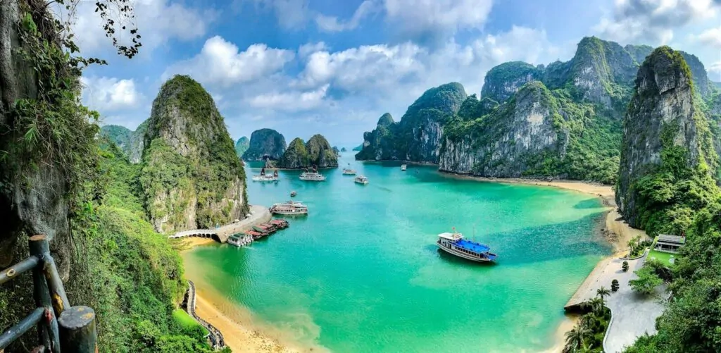 Boats on the turquoise water of Ha Long Bay surrounded by limestone karst islands