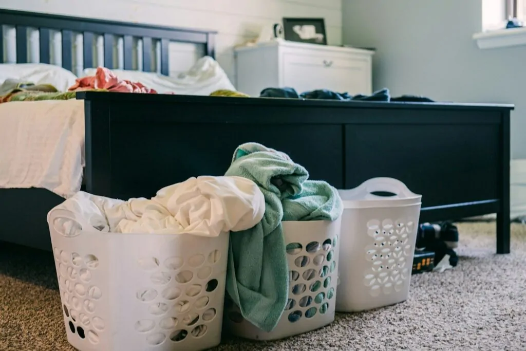 15 Ways to Organize My Life as a Busy Mom 1 three laundry baskets sitting on the floor next to a bed