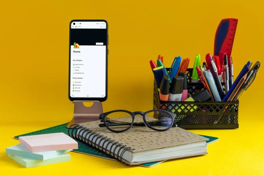 How to Restart My Life and Become Organized Again 1 a notebook, pen, glasses and cell phone on a yellow background