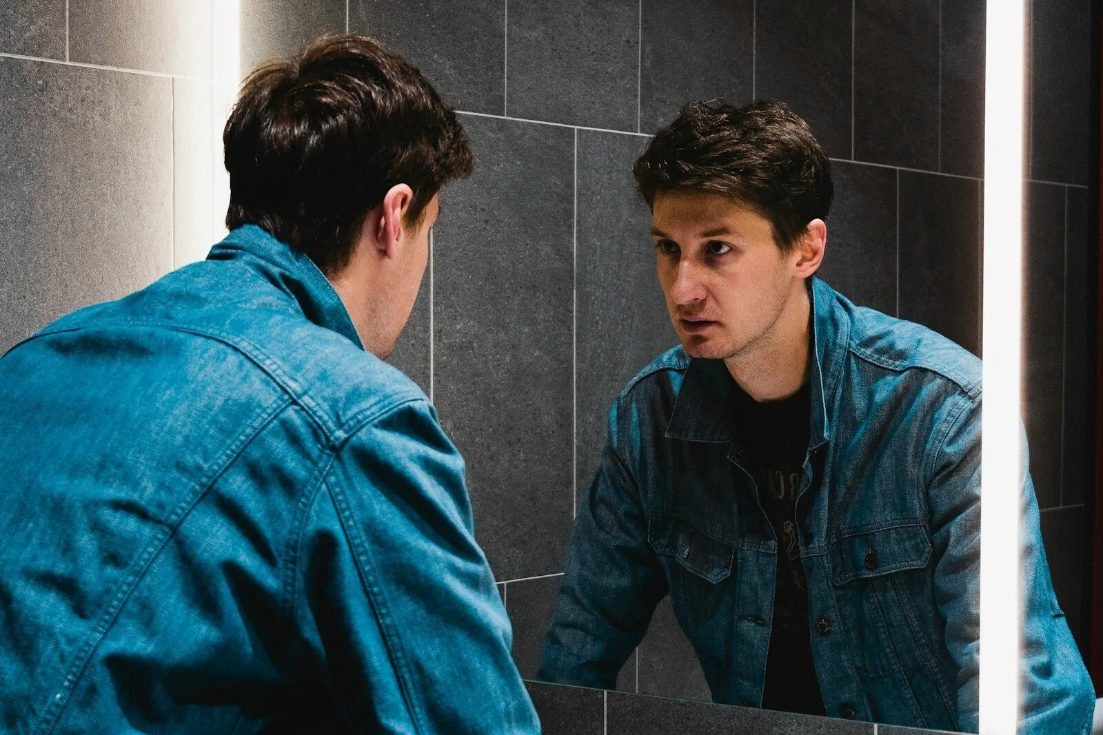 A man looking at himself in the mirror